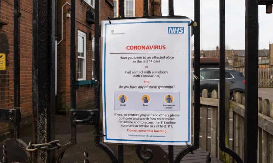 An NHS coronavirus sign attached to the gate of a primary school in London.