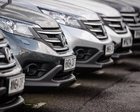 a row of grey metallic Hyundai cars parked at a showroom