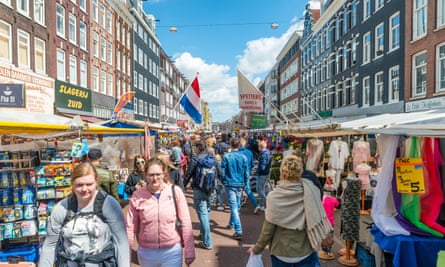 Tourists walk in Albert Cuyp Market. Albert Cuyp Market is one of sights of the city in Amsterdam, Netherlands.