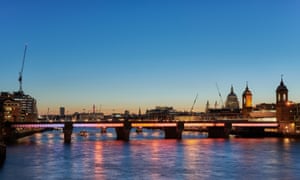 Illuminated Cannon Street bridge, with St Pauls in background