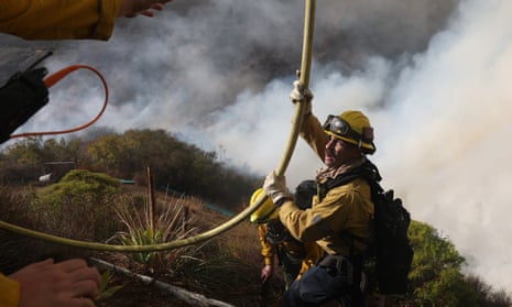 Powerful Winds Fuel Multiple Fires Across Los Angeles AreaLOS ANGELES, CALIFORNIA - JANUARY 11: Firefighters pull a hose as they battle the Palisades Fire on January 10, 2025 in Los Angeles, California. The Palisades fire had grown to over 22,000 acres and has destroyed thousands of homes. The fire is currently 11 percent contained. (Photo by Justin Sullivan/Getty Images)