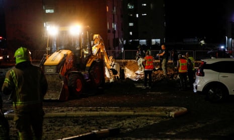 Israeli rescue force members inspect the site where a projectile fell in Haifa.