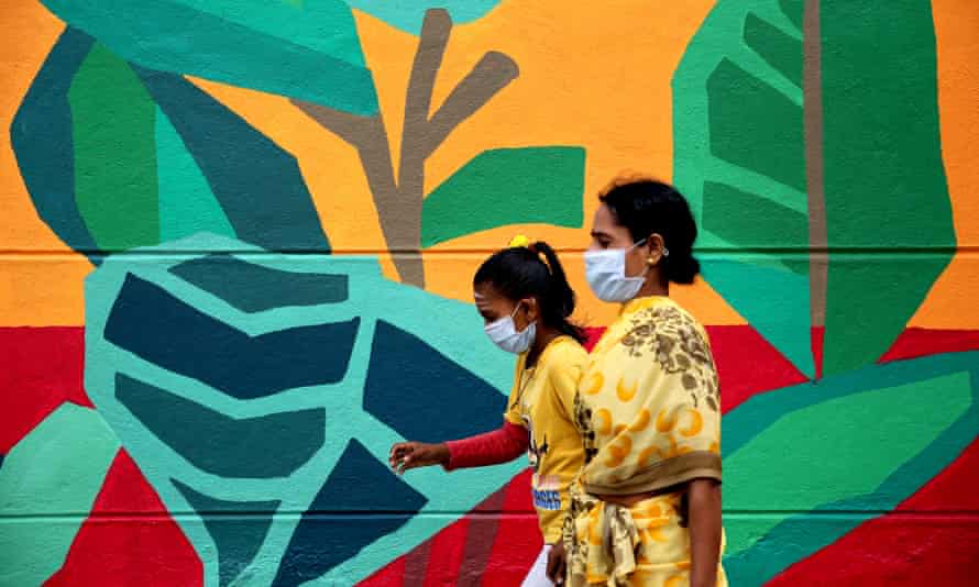 People walk past graffiti in Bengaluru.