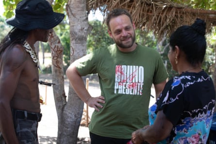 Dr Lucas Albertoni, Brazil’s chief official for recently contacted peoples, speaking to two people whose faces we can’t see, in an outdoor setting.