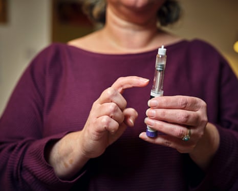 A woman prepares for a subcutaneous self-injection with a semaglutide pen 'diet drug' .
