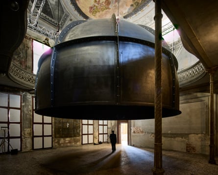 A giant metal dome hangs from the ceiling of an ornate room in Palazzo Manfrin, Venice