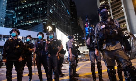 Riot police stand guard on a Hong Kong street to prevent a gathering of pro-democracy protesters.
