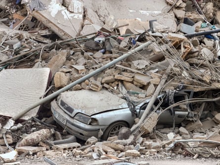 A car lies under the rubble after an Israeli strike on Beirut.