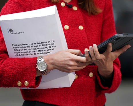 A journalist holds a copy of part of the collection of messages and emails that concern the appointment of Peter Mandelson.