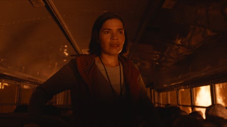 woman stands on school bus with fire outside