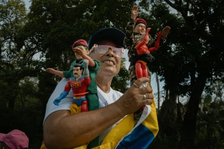 A woman holds Hugo Chavez, Nicolas Maduro and Cilia Flores figurines
