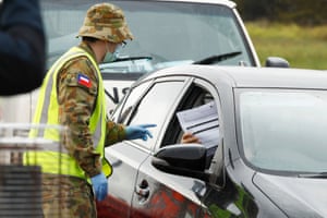 Police and ADF check work permits and identification at a roadblock in Little River today in Geelong