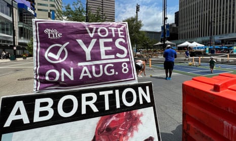 A sign asking Ohioans to vote in support of Issue 1 sits above another sign advocating against abortion rights on 20 July 20 in Cincinnati.