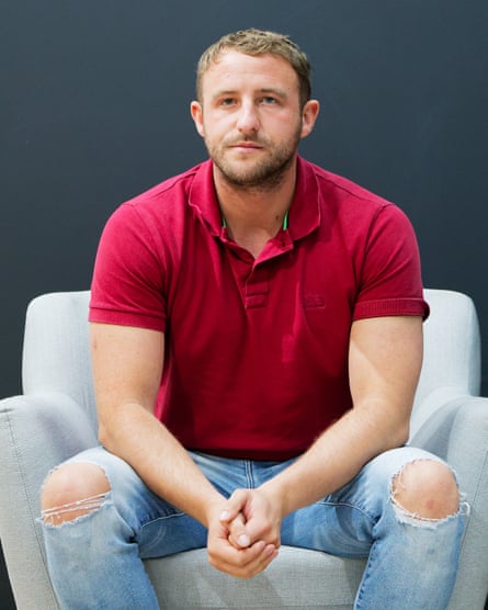Jack Harper poses for the camera while sitting in an armchair