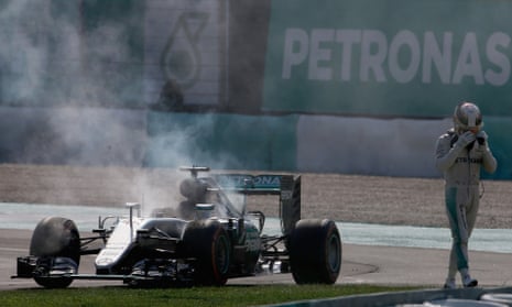 Lewis Hamilton walks away from his Mercedes after its engine caught fire while the world champion was leading the Malaysian Grand Prix on lap 41.
