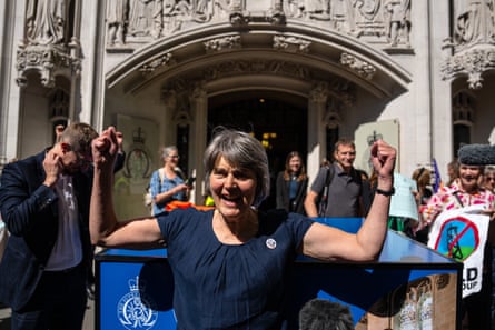 Sarah Finch celebrating outside the grey facade of the Royal Courts of Justice in London
