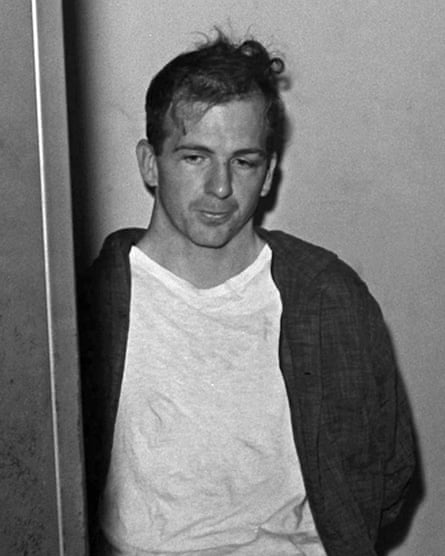 Lee Harvey Oswald sits in police custody shortly after being arrested for assassinating President John F Kennedy.