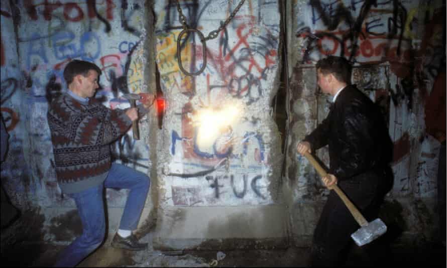 People smash chunks off the Berlin Wall on 12 November 1989