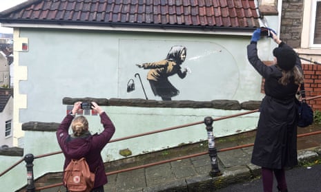 People take pictures of the new Banksy artwork