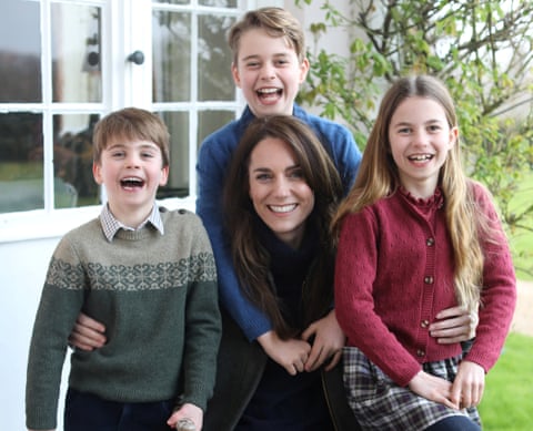 The Princess of Wales smiles as she poses outdoors for a portrait surrounded by her three children