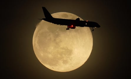 A jet is silhouetted by the rising moon as it approaches Louisville international airport in Kentucky on Monday.