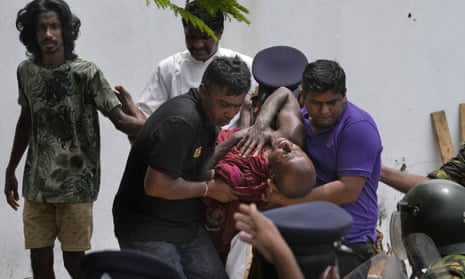 An injured Buddhist monk is carried away after attacks by government supporters on protesters in Colombo, Sri Lanka, last Monday. 