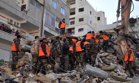 Rescue workers search for survivors among the rubble of a destroyed building in the Rihawi area in Latakia province, northwestern Syria, on 8 February 2023.  