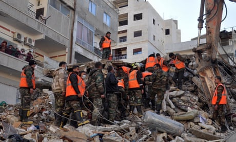 Rescue workers search for survivors among the rubble of a destroyed building in the Rihawi area in Latakia province, northwestern Syria, on 8 February 2023.