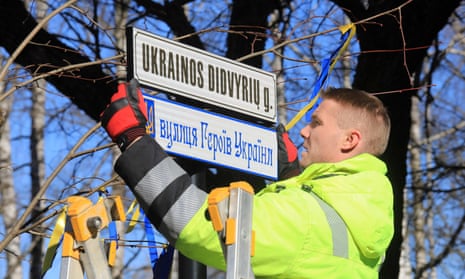 A worker fixes street plates in Lithuanian and in Ukrainian reading "Ukrainian Heroes Street" in a hitherto nameless road leading straight to the Russian embassy.