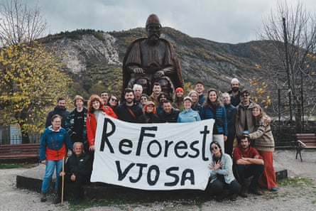 A group of people in front of a stature with a banner that reads ‘Re Forest Vjosa’