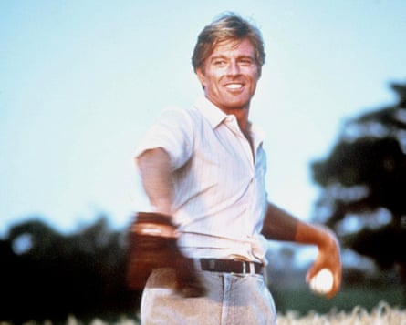 Robert Redford in white shirt with baseball mitt and holding a ball