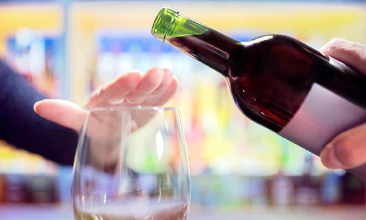 Woman’s hand rejecting more alcohol from wine bottle