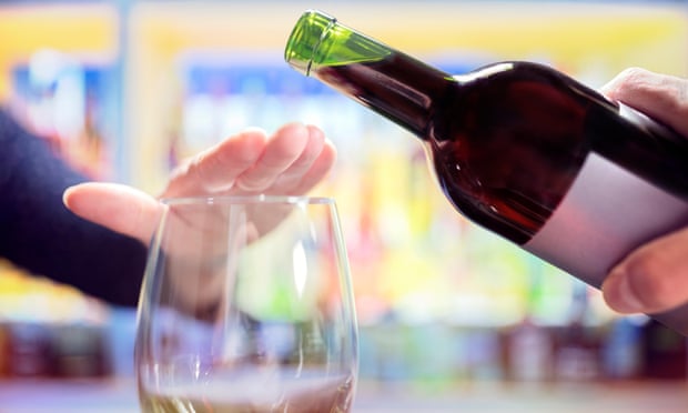 Woman’s hand rejecting more alcohol from wine bottle