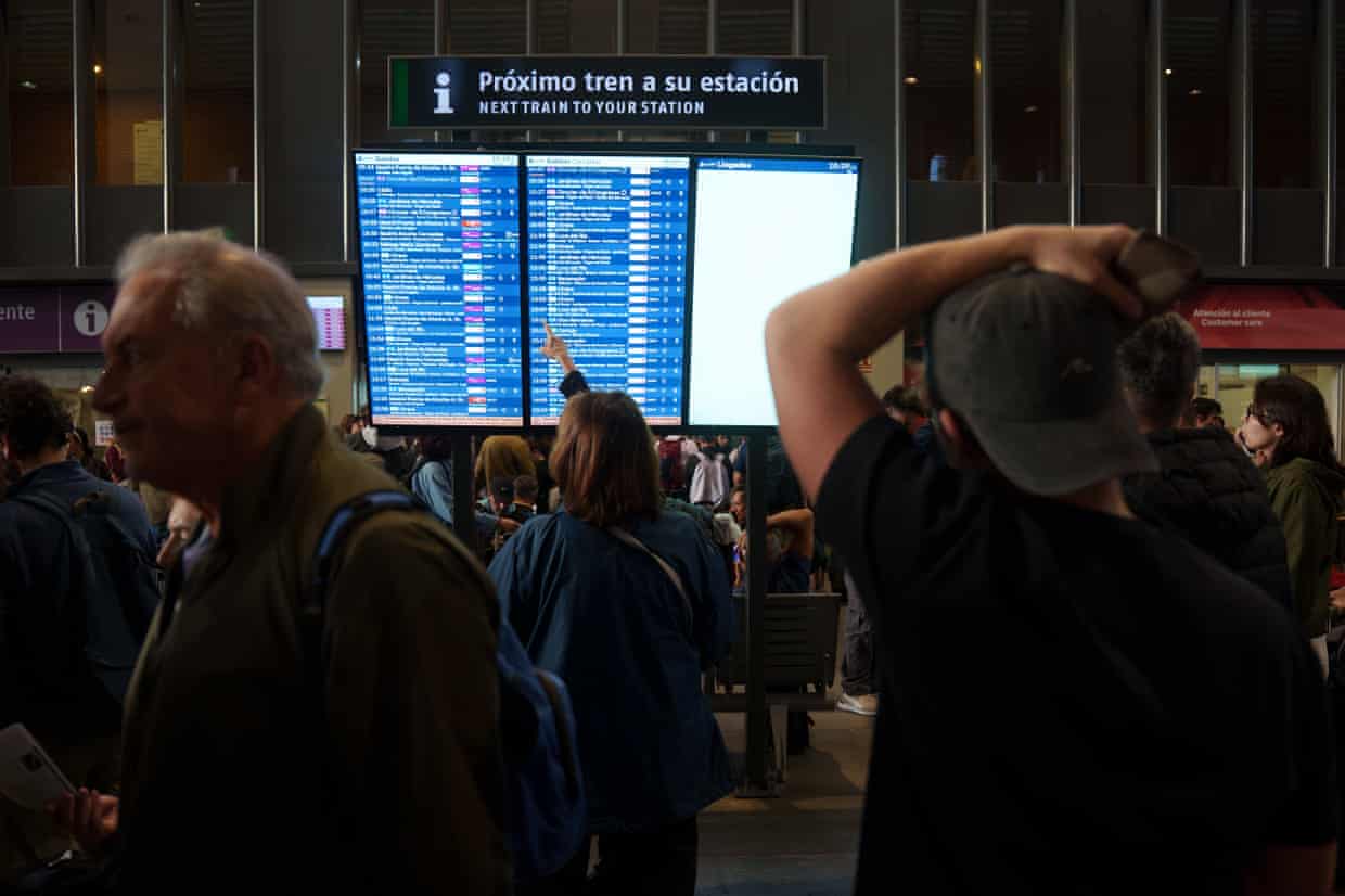 Crowds at Santa Justa station look at a departures board
