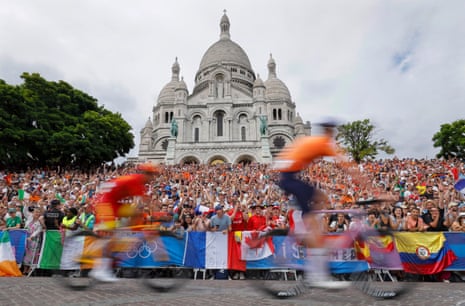 Cyclists speed past huge crowds in front of the Basilique du Sacre-Coeur at the top of Montmartre during the men’s cycling road race.