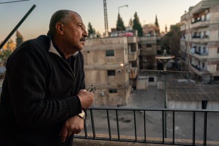 Taha Tadmori looks onto the the former political security directorate of Homs from his balcony