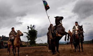 A Mapuche Indian sits on his horse as he waves the green, red and blue indigenous flag colors during a ‘Guillatun’, a spiritual ceremony to ask for the well-being of the clan and strengthen ties, in Ercilla, Chile.