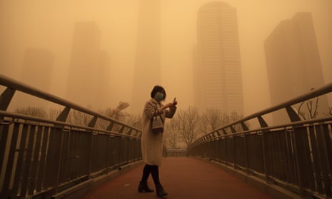 A woman walks along a pedestrian bridge during Beijing’s morning rush hour. Air pollution in China’s capital soared off the charts on Monday. 