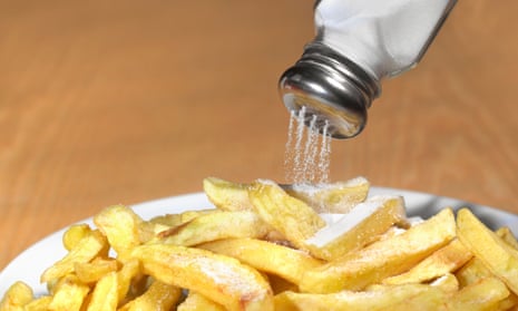 Salt being shaken on to a plate of chips.