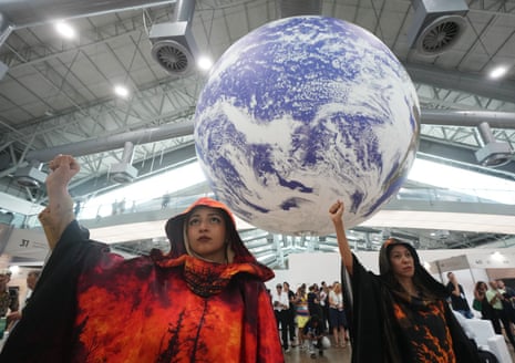 Activists participate in a demonstration under a globe at the COP30 U.N. Climate Summit, Friday, Nov. 21, 2025, in Belem, Brazil. (AP Photo/Andre Penner)