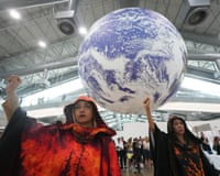 Climate activists demonstrate beneath a globe installation during the Cop30 summit in Belém, Brazil.