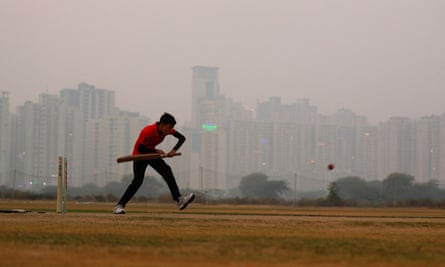 A boy plays cricket amid smog at a playground in Noida on the outskirts of Delhi, India, on 14 November.
