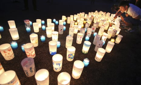 A man lights candles in Naraha, Fukushima, Japan