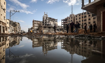 Flood water surrounds buildings that have been heavily damaged in Israeli strikes