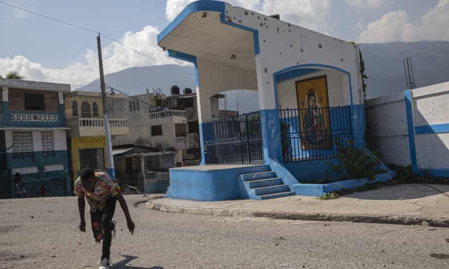 A man runs for cover as he crosses a barricaded street in the gang-controlled Bel Air neighborhood of Port-au-Prince.