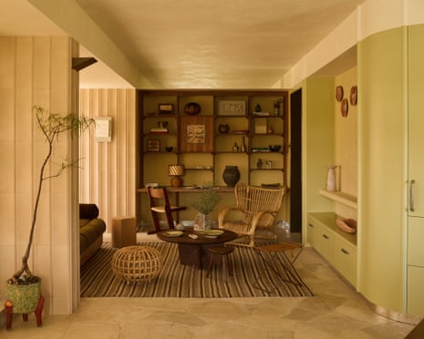 A warm living room in an apartment with a coffee table and chairs and an indoor tree