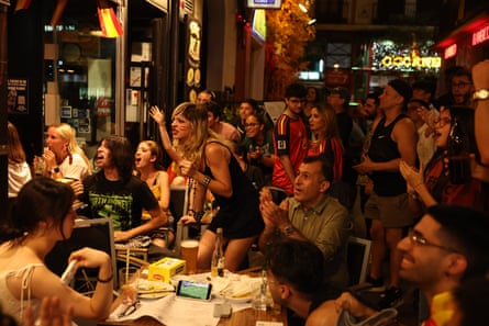 Fans in the streets of Madrid cheer as they watch the final.