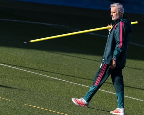 José Mourinho holds a yellow pole on a training pitch