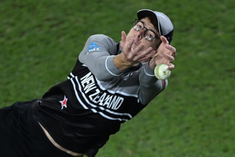 Mitch Santner of New Zealand drops Sam Curran on the boundary.