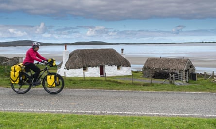 Traditional Hebridean White House and cyclist